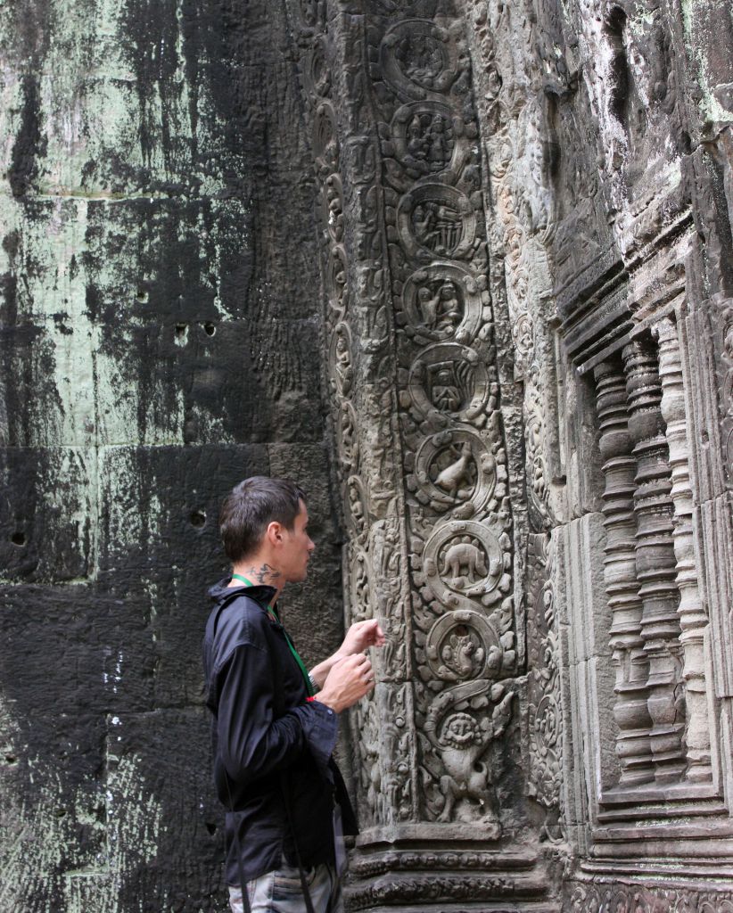 Та Пром. На стенах храмов - гид показывает изображения динозавров и невиданных животных - Путешествие группы МироТворцев по Камбодже, декабрь 2012г.