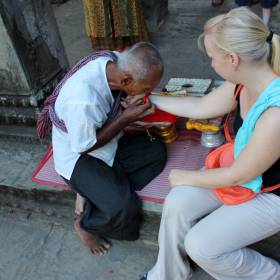 Монах с молитвой повязывает нам охранные обереги - Путешествие  по Камбодже, декабрь 2012г.